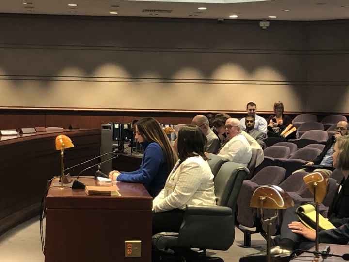 Ciara Rosati, Smart Justice leader, testifies in support of strong Clean Slate, SB 403, at the CT General Assembly in 2020. Ciara wears a blue shirt and is seated next to policy counsel Kelly Moore, in a white blazer.