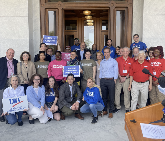 ACLU-CT staff and partners are posing in front of the camera with signs to promote the CTVRA.